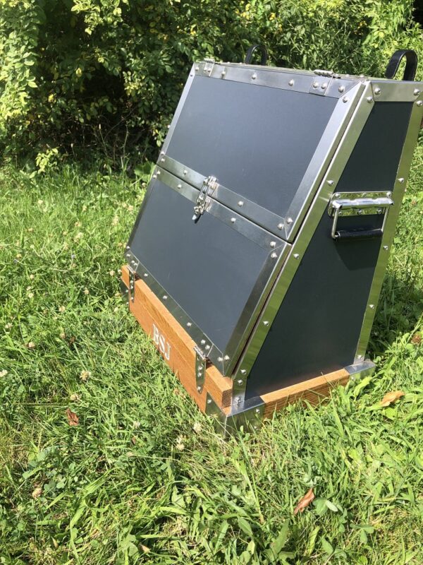 Dark gray metal tack trunk outdoors.