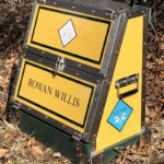 Here's an 8-word alt tag for the image: Yellow Rowan Willis Voltaire Design horse tack trunk.