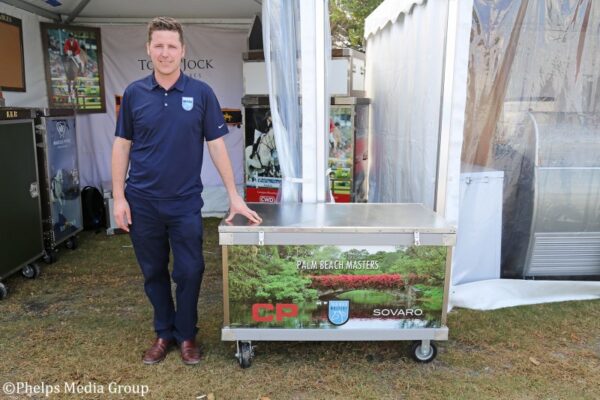 Man standing by Palm Beach Masters box.