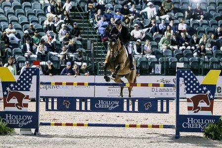 Rider jumping horse over a fence.