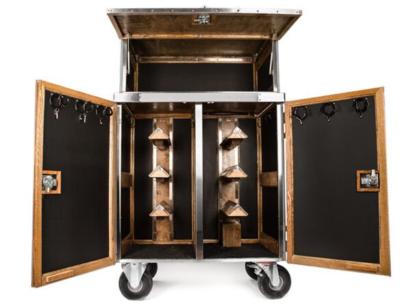 Here's an alt tag for the image: > Wooden tack trunk with bridle hooks and saddle racks.