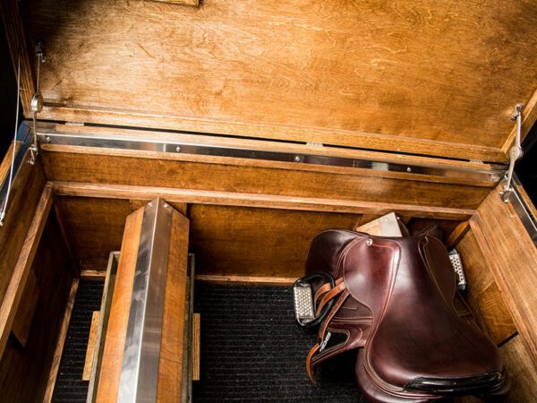 Wooden saddle trunk with leather saddle inside.