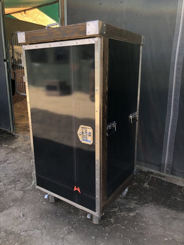 Black metal tack trunk on wheels.