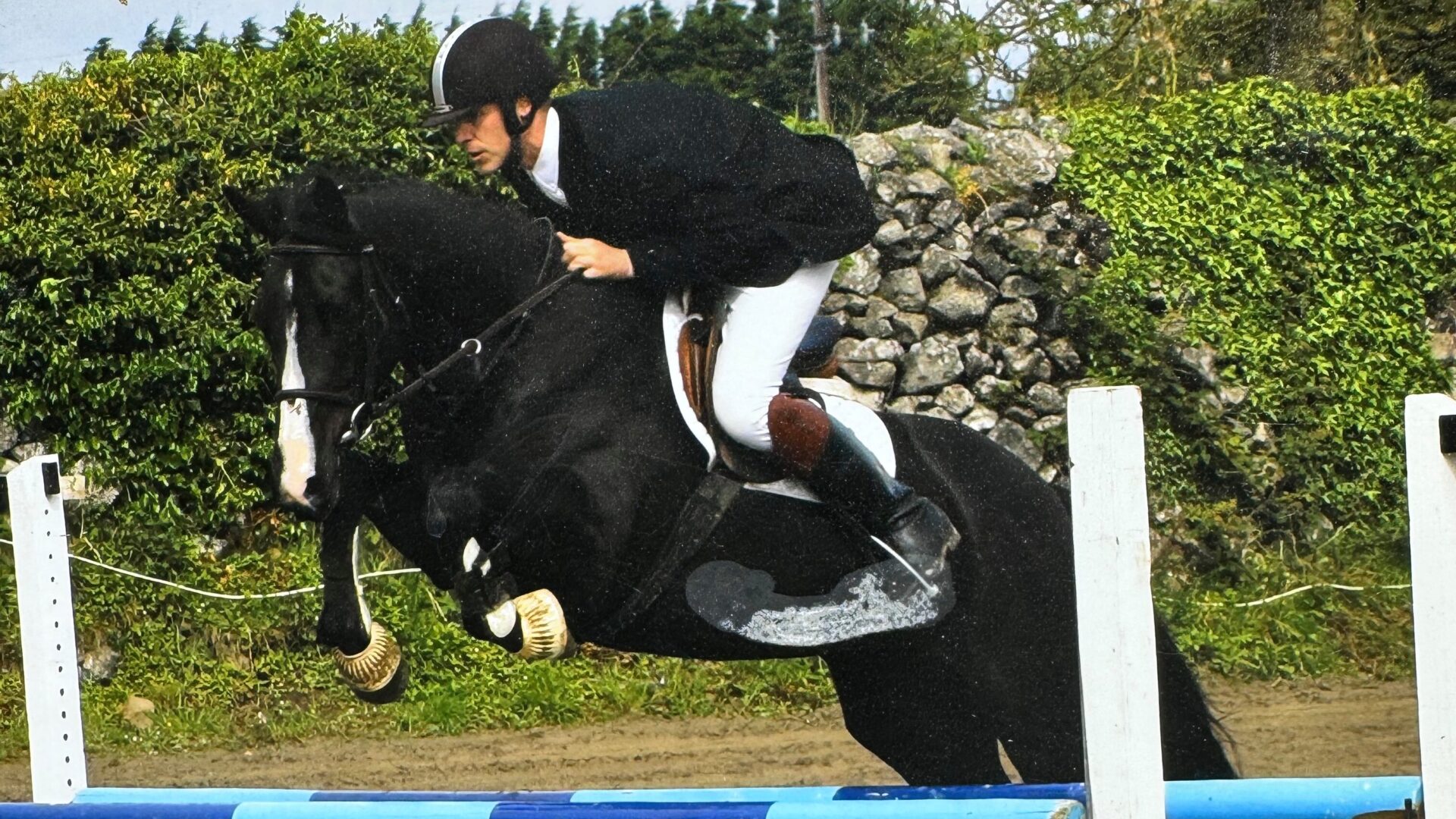 A man riding on the back of a black horse.